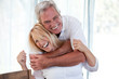 Jolly senior man hugging wife