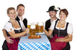 Bayrische Männer und Frauen stossen mit Oktoberfest Maß Bier an