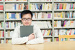 Handsome man sitting and reading in library