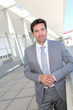 Handsome businessman standing in front of building