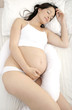 Foto: Pregnant woman lying in bed sleeping Pregnant woman lying in bed sleeping