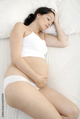 Photo: Unhappy pregnant woman laying in bed Unhappy pregnant woman laying in bed