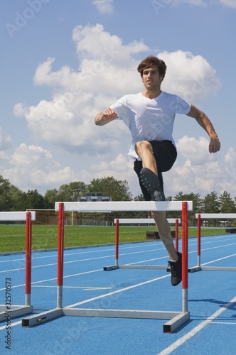 Photo: Man Jumping Hurdles On A Track Man Jumping Hurdles On A Track