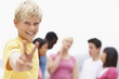 Smiling boy gesturing a peace sign and friends at the back