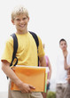 School boy holding files with friends at the back