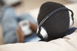 Rear view of a young boy on the sofa listening to music