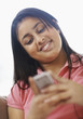 Smiling teen girl using a cellphone to text message