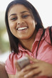 Happy young girl using cellphone to text message