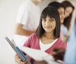 Cute school girl with notes and other students at the back