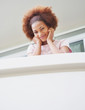 Happy cute young woman at her balcony