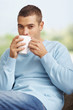 Smart young guy drinking beverage