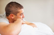 Photo: Young man daydreaming while lying on bed Young man daydreaming while lying on bed