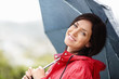 Foto: Smiling woman in red raincoat holding an umbrella Smiling woman in red raincoat holding an umbrella