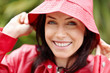 Foto: Smiling cute woman in red raincoat outdoors Smiling cute woman in red raincoat outdoors