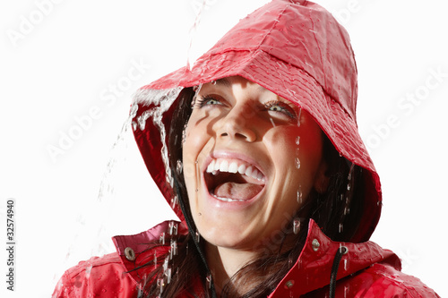 Photo: Young woman in red raincoat excited about the rain Young woman in red raincoat excited about the rain
