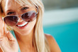 Happy young woman looking through sun glasses