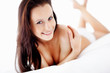 Photo: Portrait of a happy cute topless woman lying on bed Portrait of a happy cute topless woman lying on bed