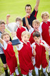 Victorious soccer team holding up trophy in joy