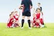 Foto: Soccer instructor in conversation with players on field Soccer instructor in conversation with players on field