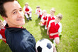 Soccer coach giving you a smile with players on field