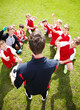 Soccer coach cheering his team players on field