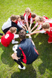 Soccer team putting hands together in huddle before a match
