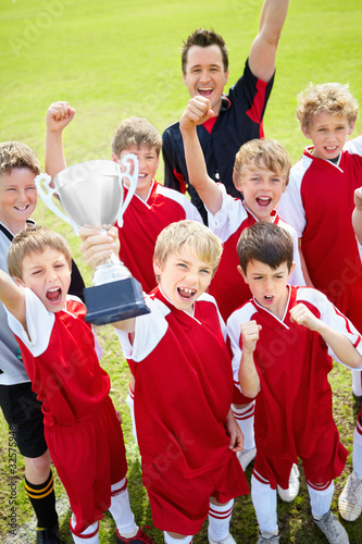 Foto: Victorious soccer team holding up trophy in joy Victorious soccer team holding up trophy in joy