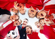 Excited soccer team with coach forming a huddle
