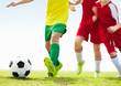 Low angle shot of players kicking football on field