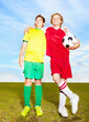Two rival soccer players standing arm in arm on field