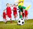 Football kids with rival player about to kick the ball on field