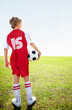 Rear view of a football player holding a ball on field