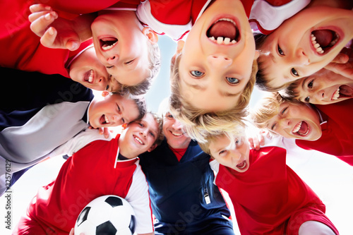 Photo: Upward view of soccer team forming a huddle together Upward view of soccer team forming a huddle together