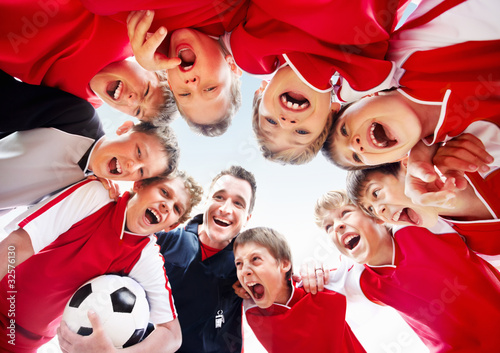 Foto: Excited soccer team with coach forming a huddle Excited soccer team with coach forming a huddle
