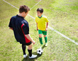 Coach with a young football player on field