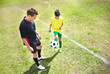 Coach with a male player on soccer field