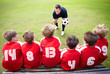 Football coach motivating little players before a match