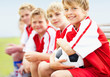 Closeup of a relaxed soccer kid sitting with his team mates