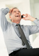 Senior business man laughing while using on cell phone