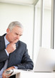 Thoughtful senior business man looking at laptop