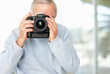 Mature photographer taking picture with his digital camera