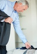 Mature business man trying to choose the right tie for his suit