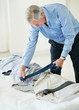 An elderly man trying to choose the right tie for his shirt