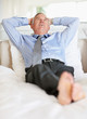 Relaxed mature business man lying in bed while looking away
