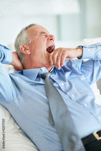 Photo: Sleepy elderly business man yawning Sleepy elderly business man yawning