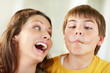 Child making funny faces in front of his mother