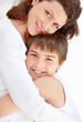 Photo: Happy young boy hugging his mother against white Happy young boy hugging his mother against white