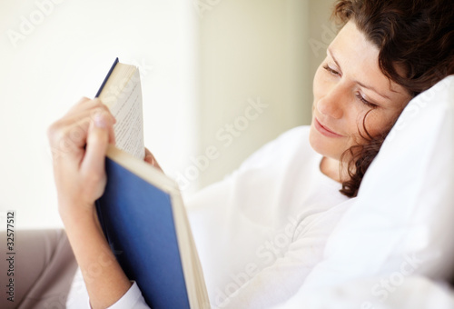 Photo: Happy middle aged woman reading book Happy middle aged woman reading book