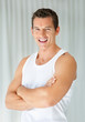 Cheerful young man with hands crossed smiling