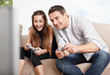 Happy father and daughter playing video games at home